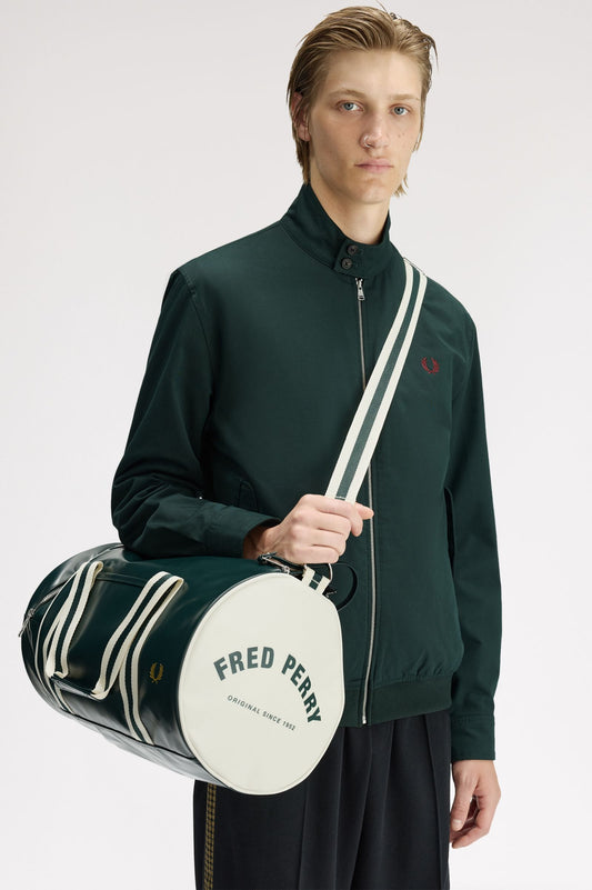 Person holding a Fred Perry duffel bag against a white background