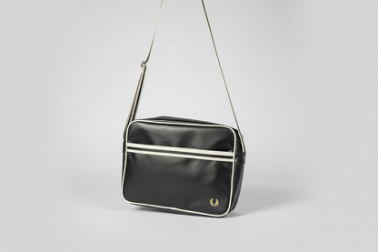 Black shoulder bag with white accents on a light gray background