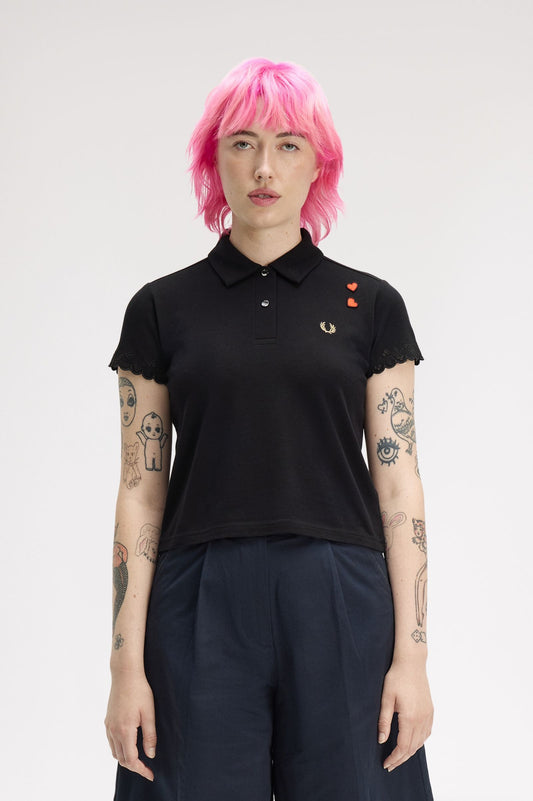 Person wearing a black polo shirt with a brand logo on a white background