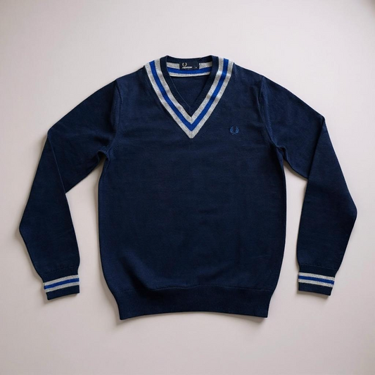 Navy blue sweater with white and blue stripes on a light gray background