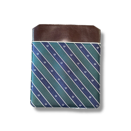 A Fred Perry branded iPad sleeve with a geometric pattern in blue and green colors, complemented by a brown leather trim at the top.