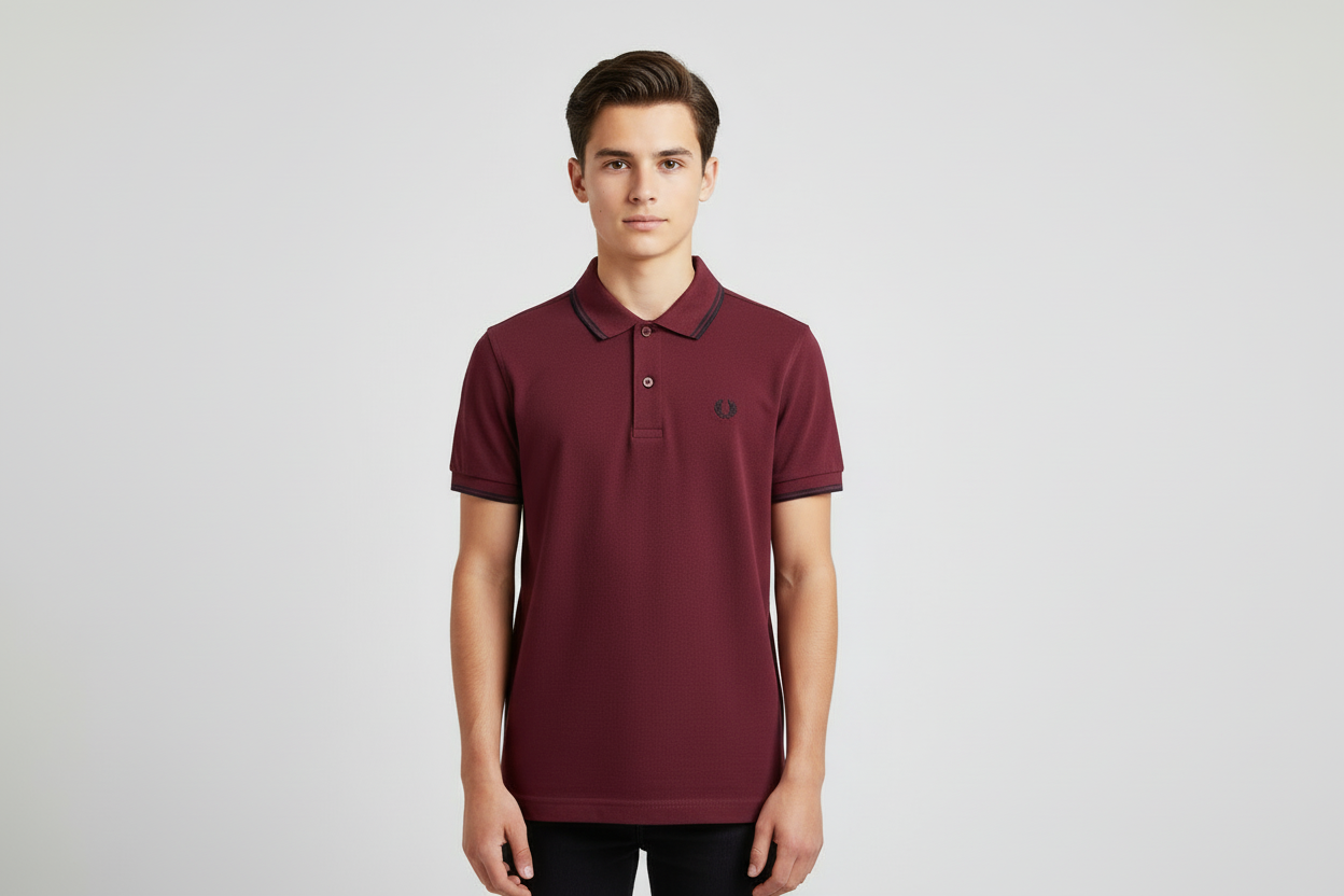 Man wearing a maroon polo shirt with a brand logo on a light gray background