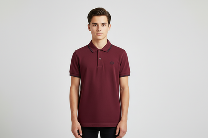 Man wearing a maroon polo shirt with a brand logo on a light gray background