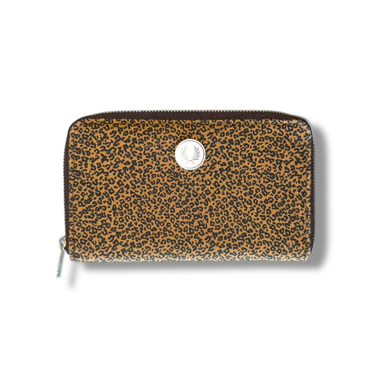 A leopard print long purse with a zipper closure and a metallic logo at the top center.