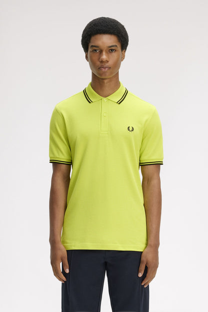 Person wearing a bright yellow polo shirt with black trim on a white background