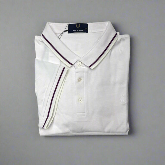 Folded white polo shirt with purple trim on a white background