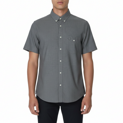 Person wearing a gray short-sleeve button-up shirt on a white background