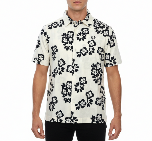 Man wearing a white shirt with black floral pattern on a white background