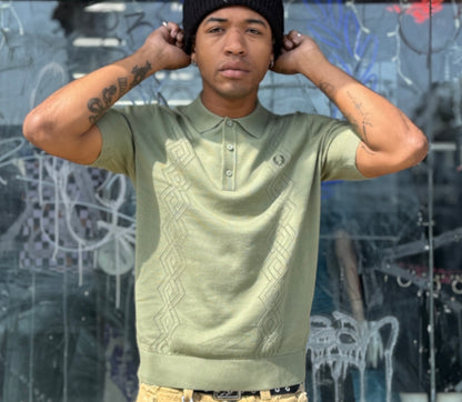 A male model wearing a green Fred Perry pointelle knitted shirt with a crew neckline and short sleeves.