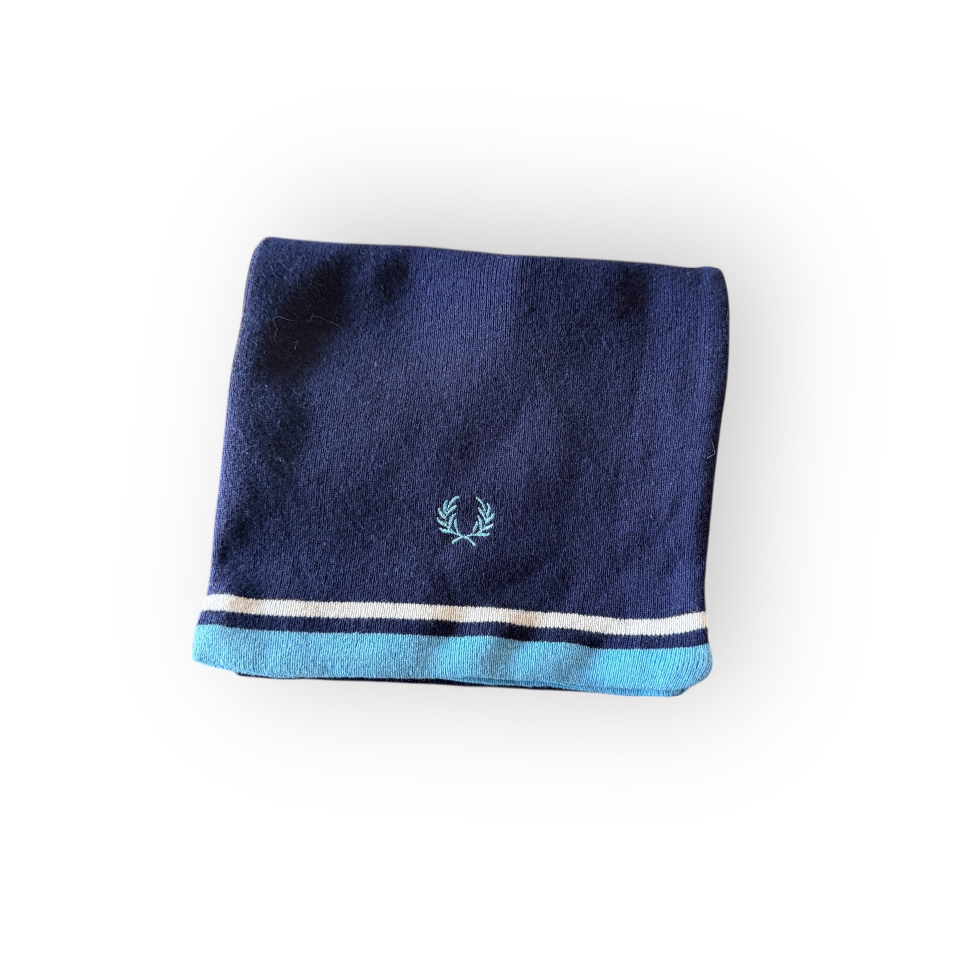 A folded navy blue and white scarf with the Fred Perry logo on the corner.
