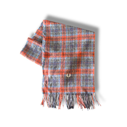 A tartan patterned scarf in red, blue, and gray colors with fringes and a button detail.