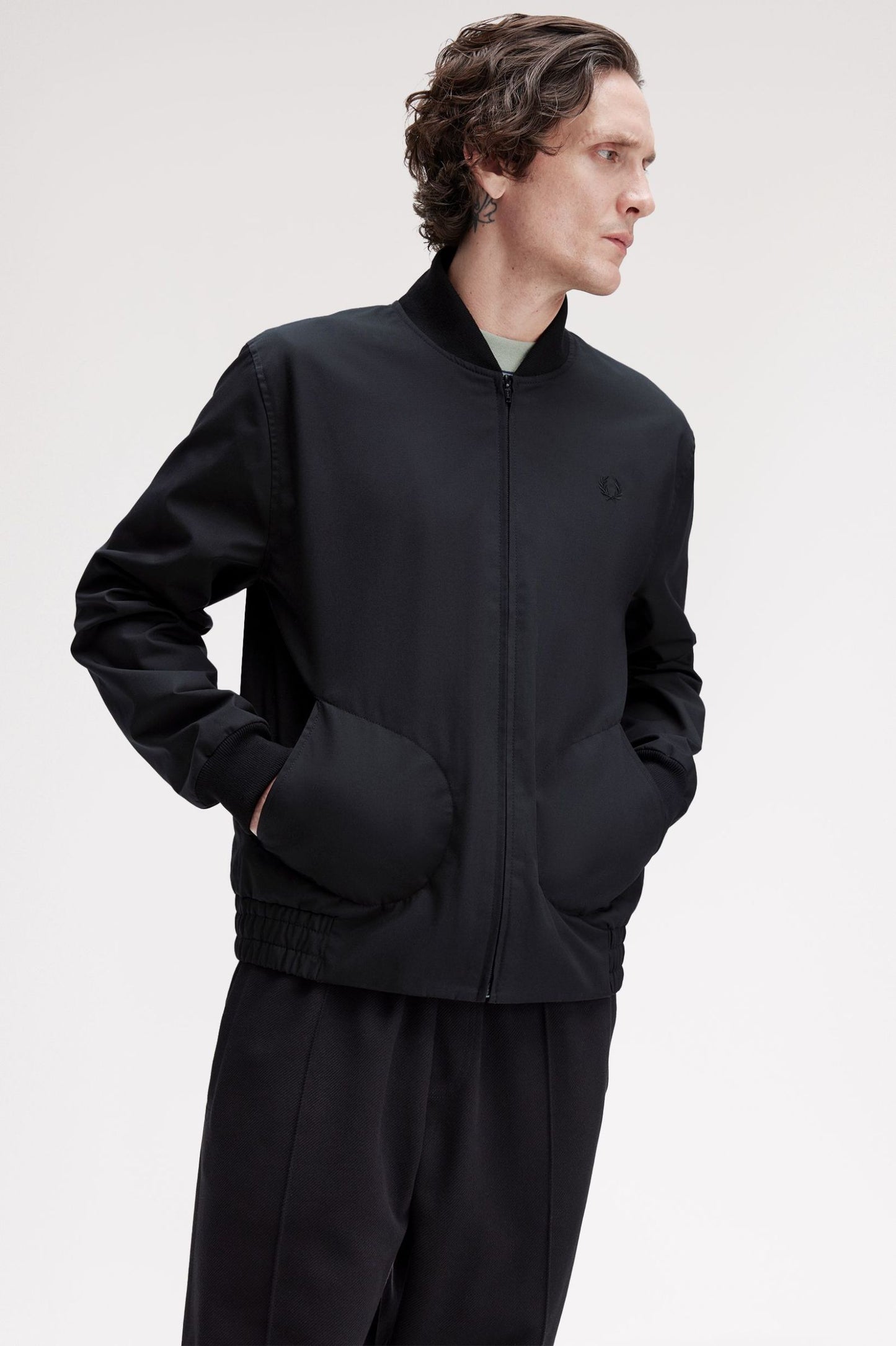 Man wearing a black jacket and pants on a white background
