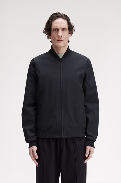 Man wearing a black jacket and pants on a white background
