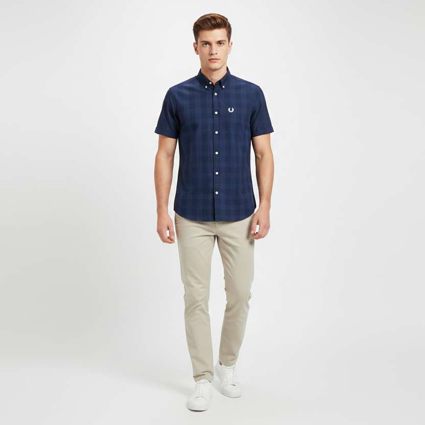 Man wearing a navy checkered shirt and beige pants on a white background