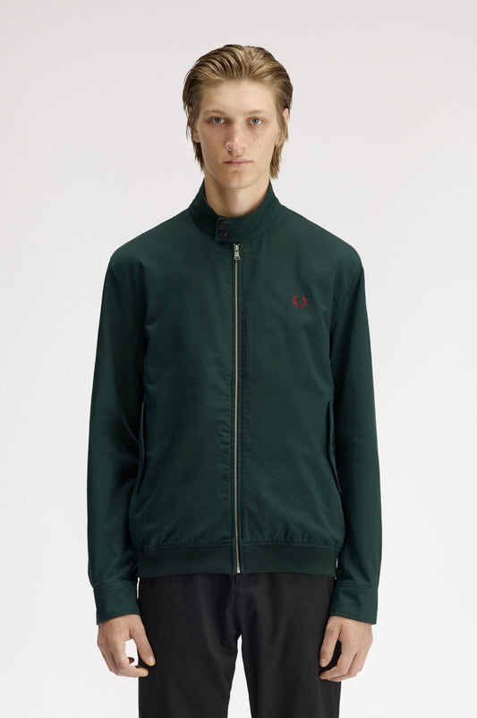 Man wearing a green jacket with a red logo on a white background