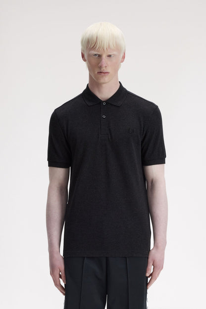 Person wearing a black polo shirt on a white background