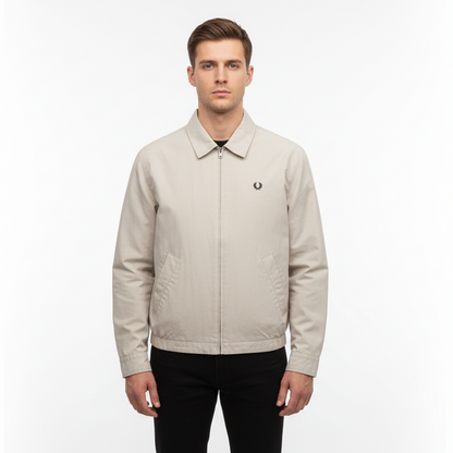 Man wearing a beige jacket with a brand logo on a white background