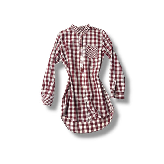 An oversized gingham print shirt with long sleeves and a collar, featuring a red and white checkered pattern.