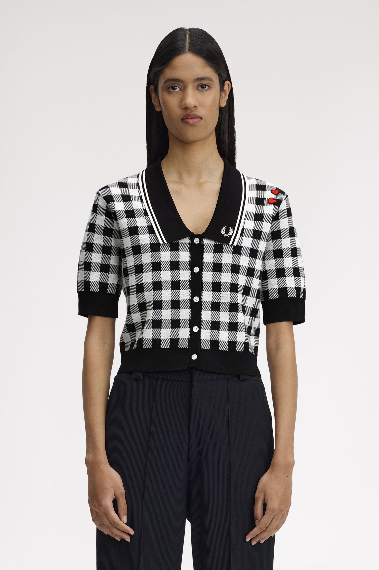 Person wearing a black and white checkered shirt with a brand logo on a white background