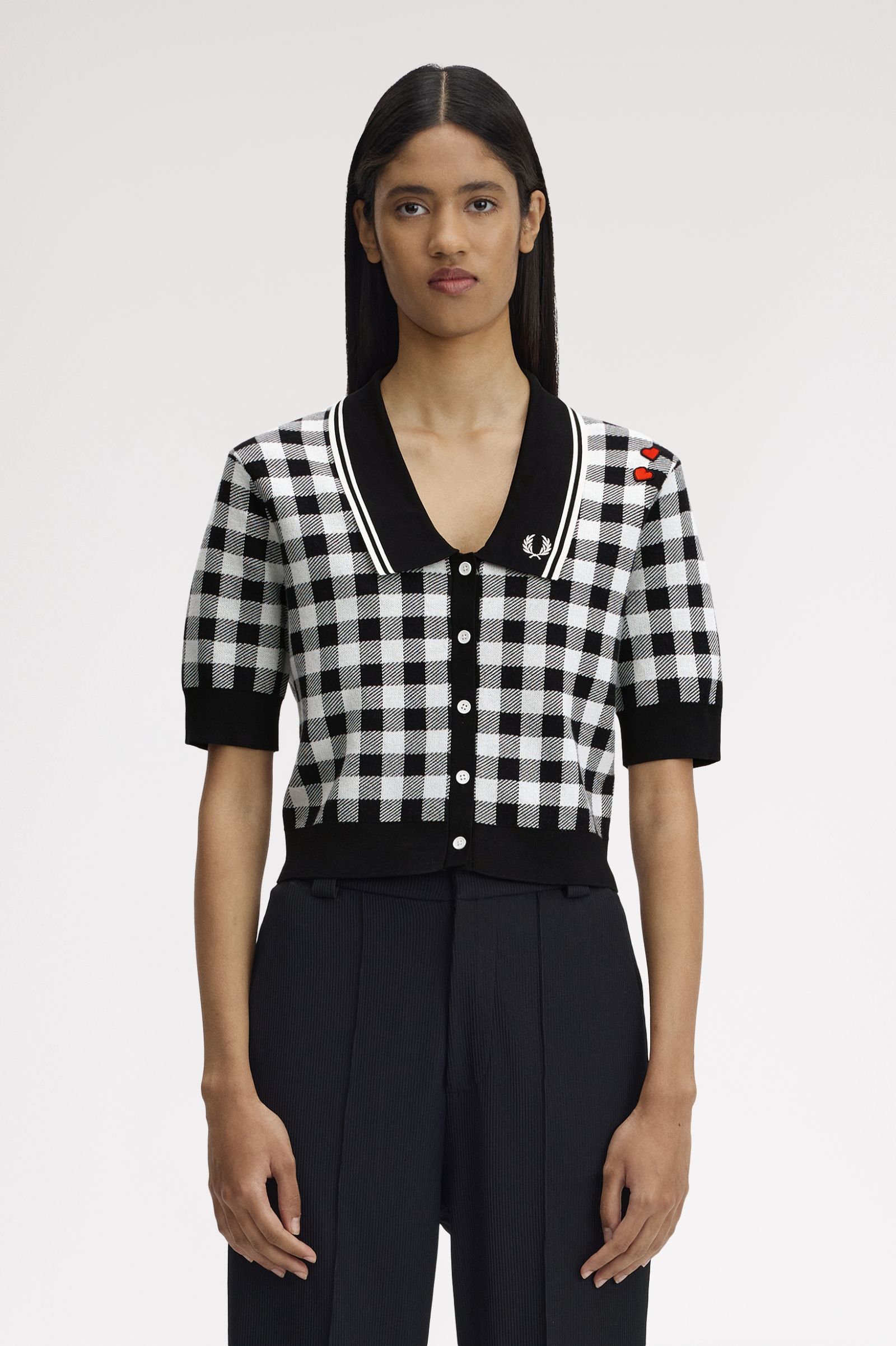 Person wearing a black and white checkered shirt with a brand logo on a white background