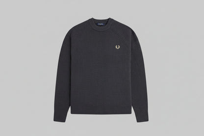 Black ribbed sweater with a brand logo on a light gray background