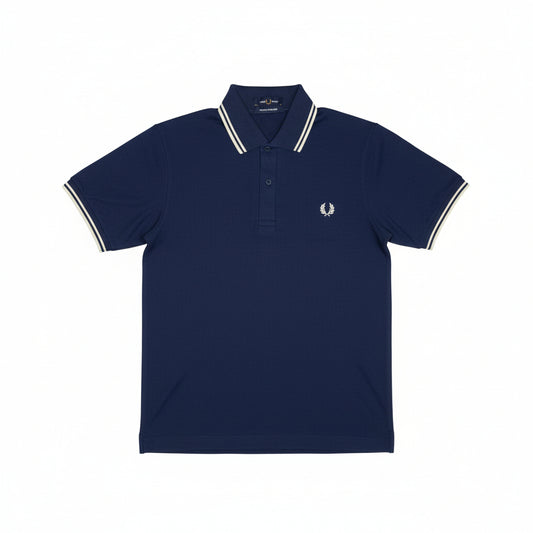 A folded blue Fred Perry polo shirt with white stripes on the collar and chest logo