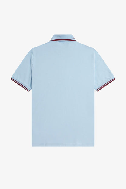 Light blue polo shirt with red and white trim on a white background