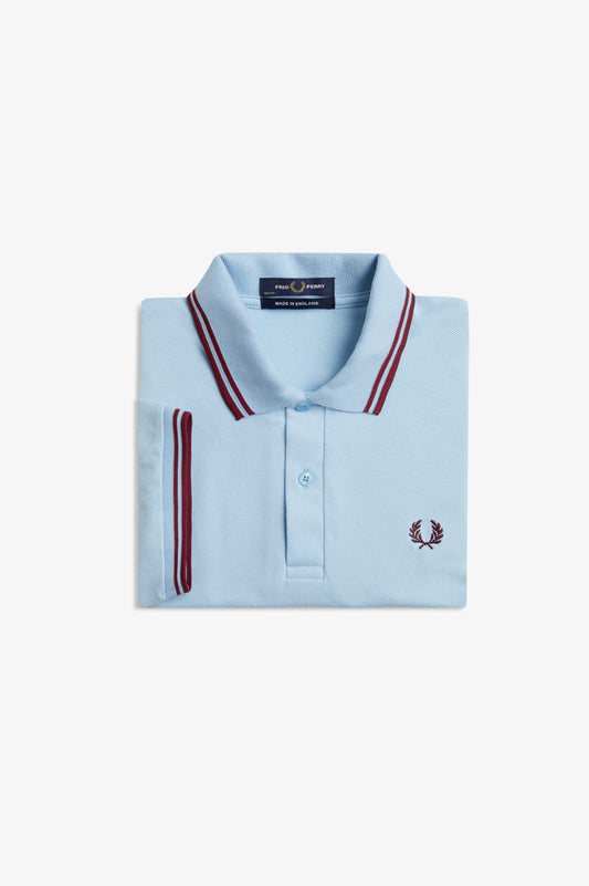 Light blue polo shirt with red accents on a white background