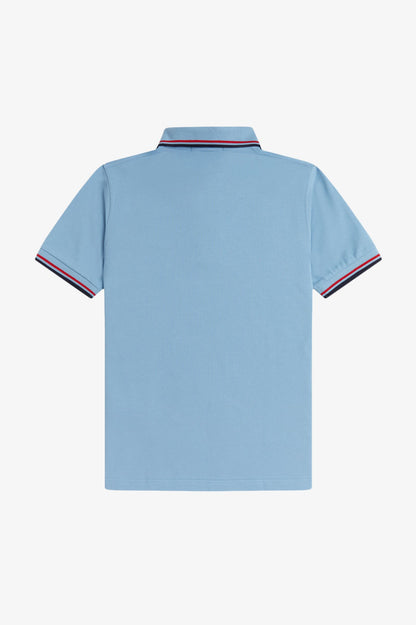 Light blue polo shirt with red and navy trim on a white background