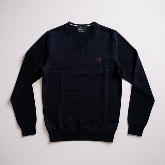 Navy blue sweater with a small logo on a light gray background