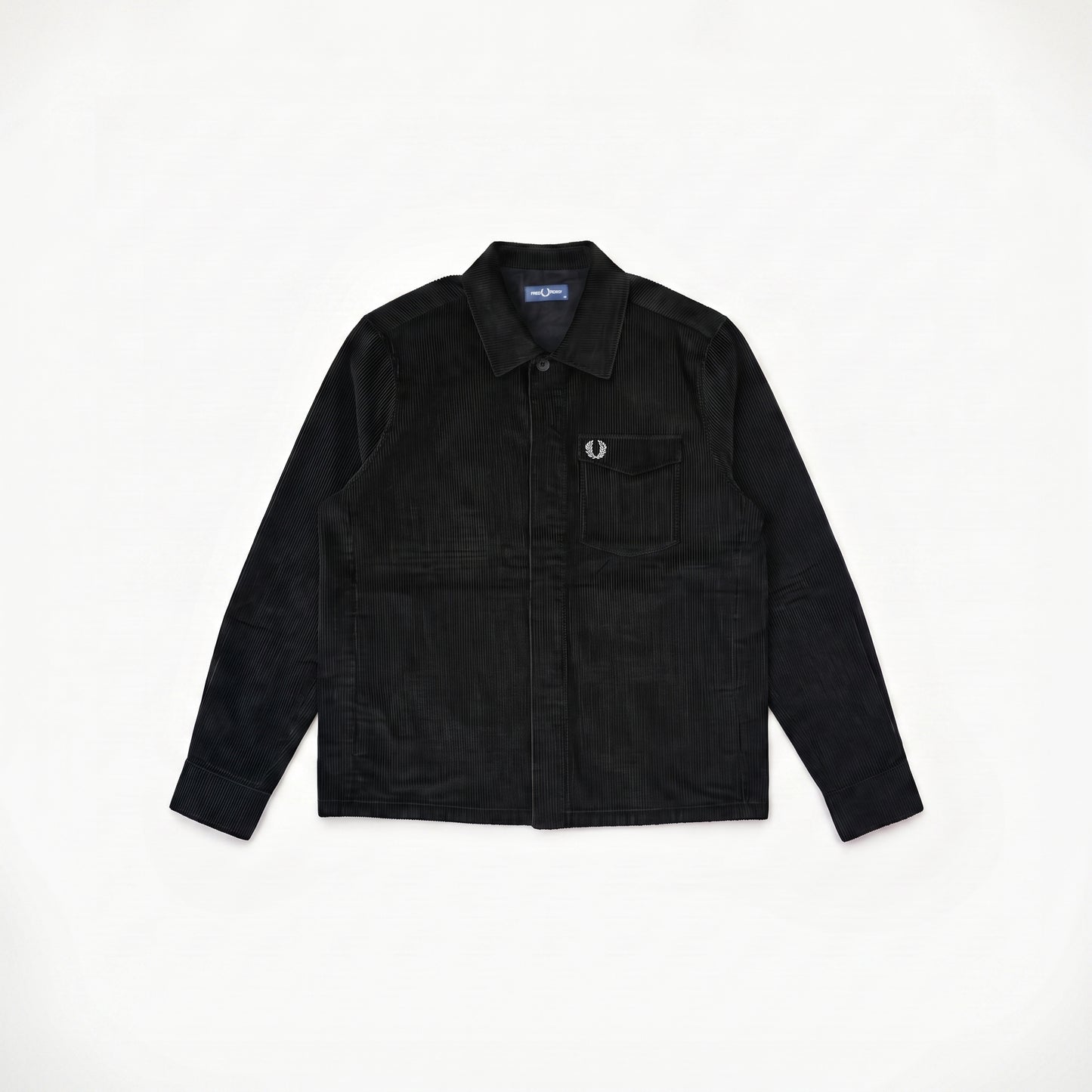 A black corduroy button-up shirt jacket with a chest pocket and a small embroidered logo, laid flat on a white background.