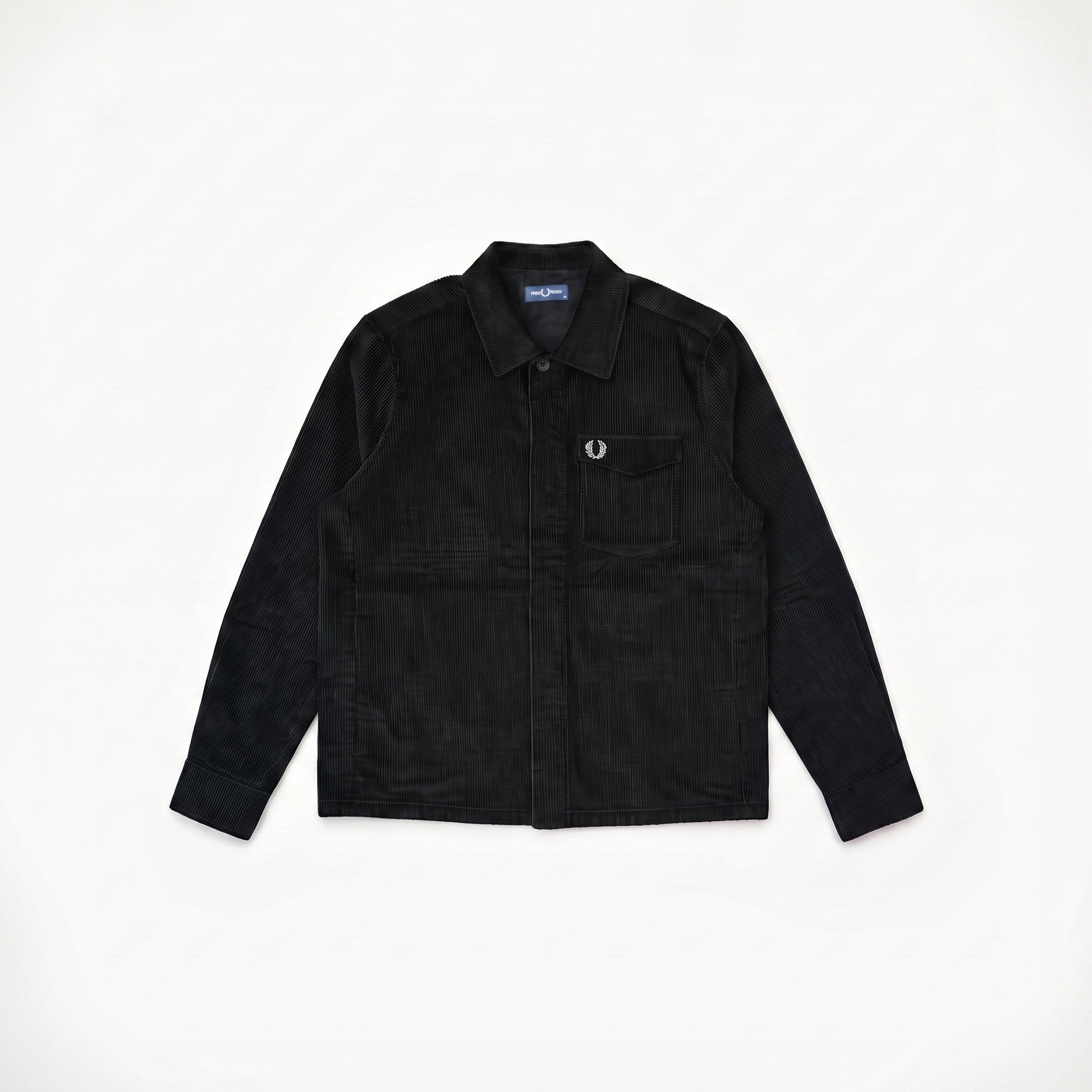 A black corduroy button-up shirt jacket with a chest pocket and a small embroidered logo, laid flat on a white background.