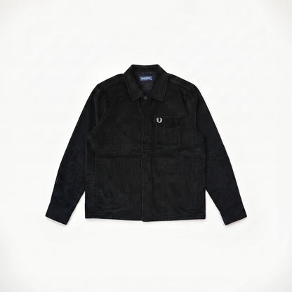 A black corduroy button-up shirt jacket with a chest pocket and a small embroidered logo, laid flat on a white background.