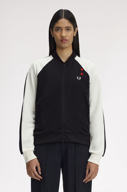 Person wearing a black and white jacket with a red logo on a white background