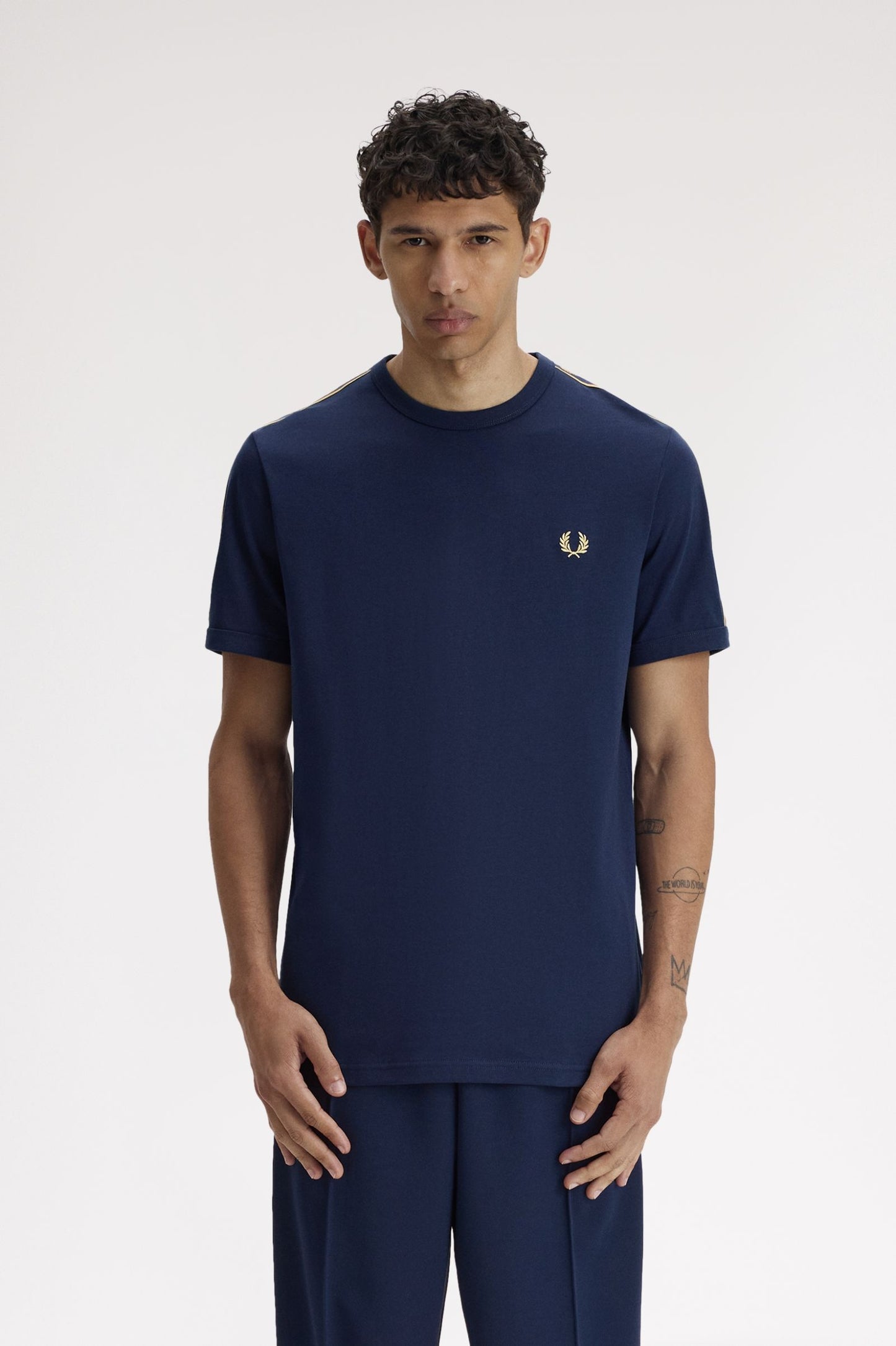 Man wearing a navy blue t-shirt with a logo on a white background