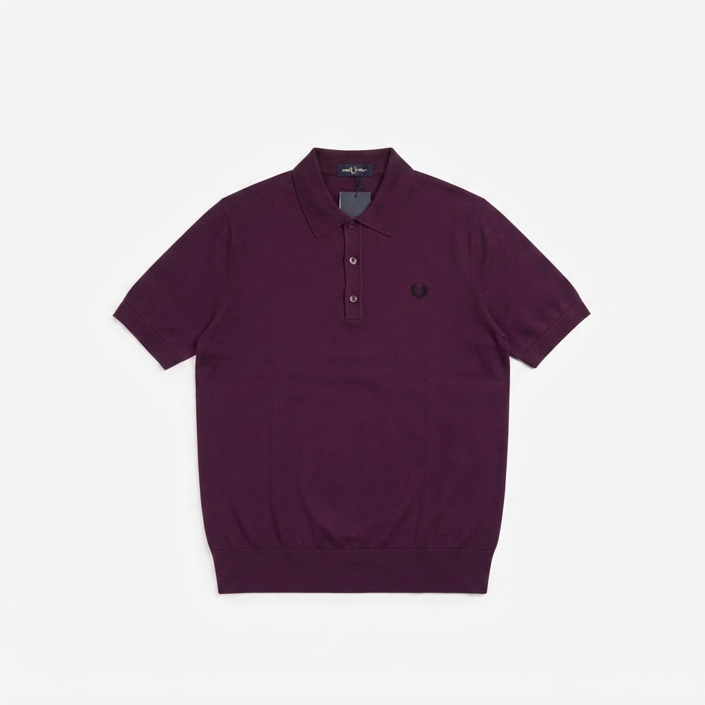 A short-sleeve polo shirt in deep plum purple, featuring a three-button placket and the signature embroidered laurel leaf logo on the left chest, displayed flat against a light gray background.