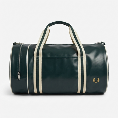 A dark green leather duffel bag with cream-colored vertical stripes on the handles and sides, featuring a gold embroidered laurel wreath logo on the front right and a zippered side pocket, set against a plain light gray background.