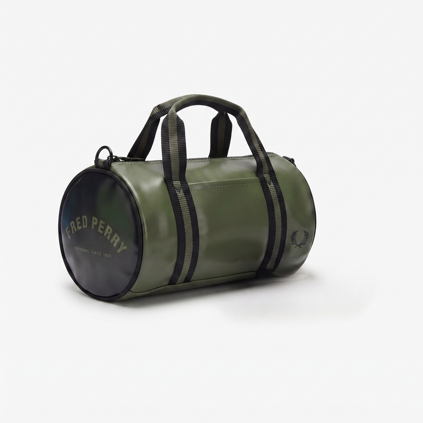 An olive green cylindrical duffel bag by Fred Perry, featuring black webbing handles, black side stripes, and a black circular end cap with gold lettering, set against a plain white background.
