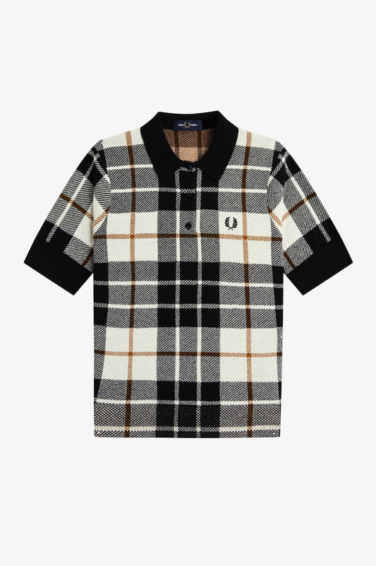 A short-sleeve knit polo shirt by Fred Perry featuring a black, beige, and white plaid pattern with a black collar and sleeve cuffs. The iconic embroidered laurel wreath logo is visible on the left chest.