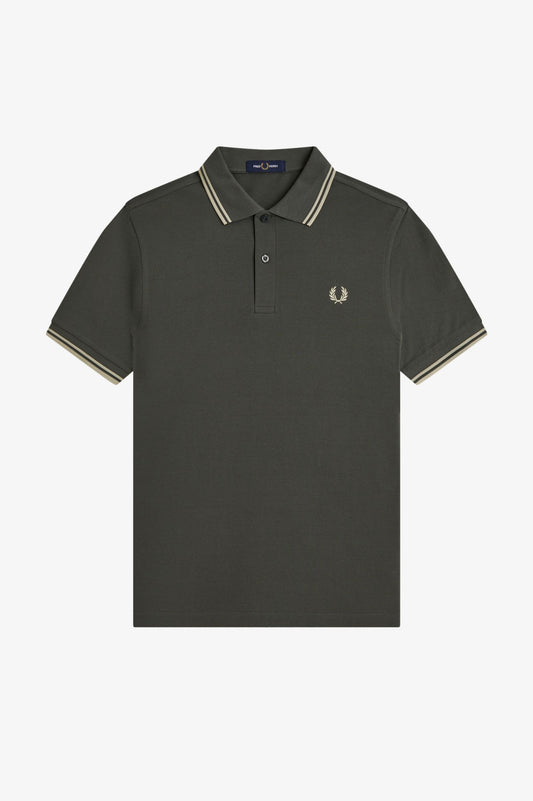 A dark olive green short-sleeve polo shirt with cream and navy striped trim on the collar and sleeve cuffs, featuring the embroidered Fred Perry laurel wreath logo on the left chest, displayed on a clean white background.
