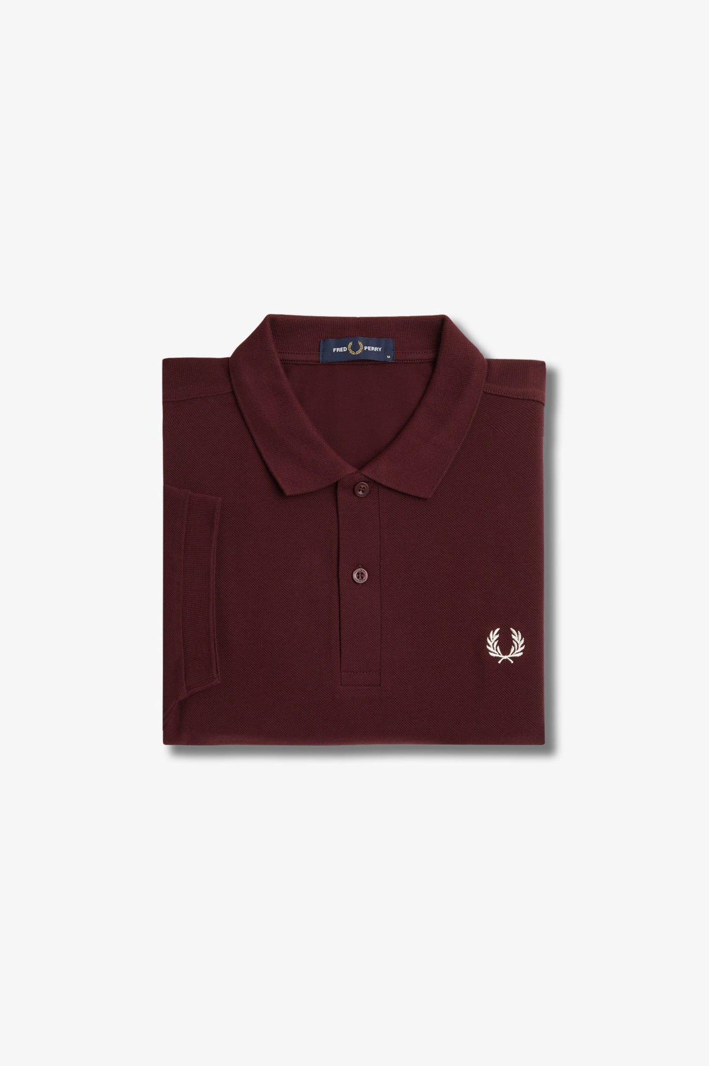 Folded burgundy polo shirt with a brand logo on a light gray background