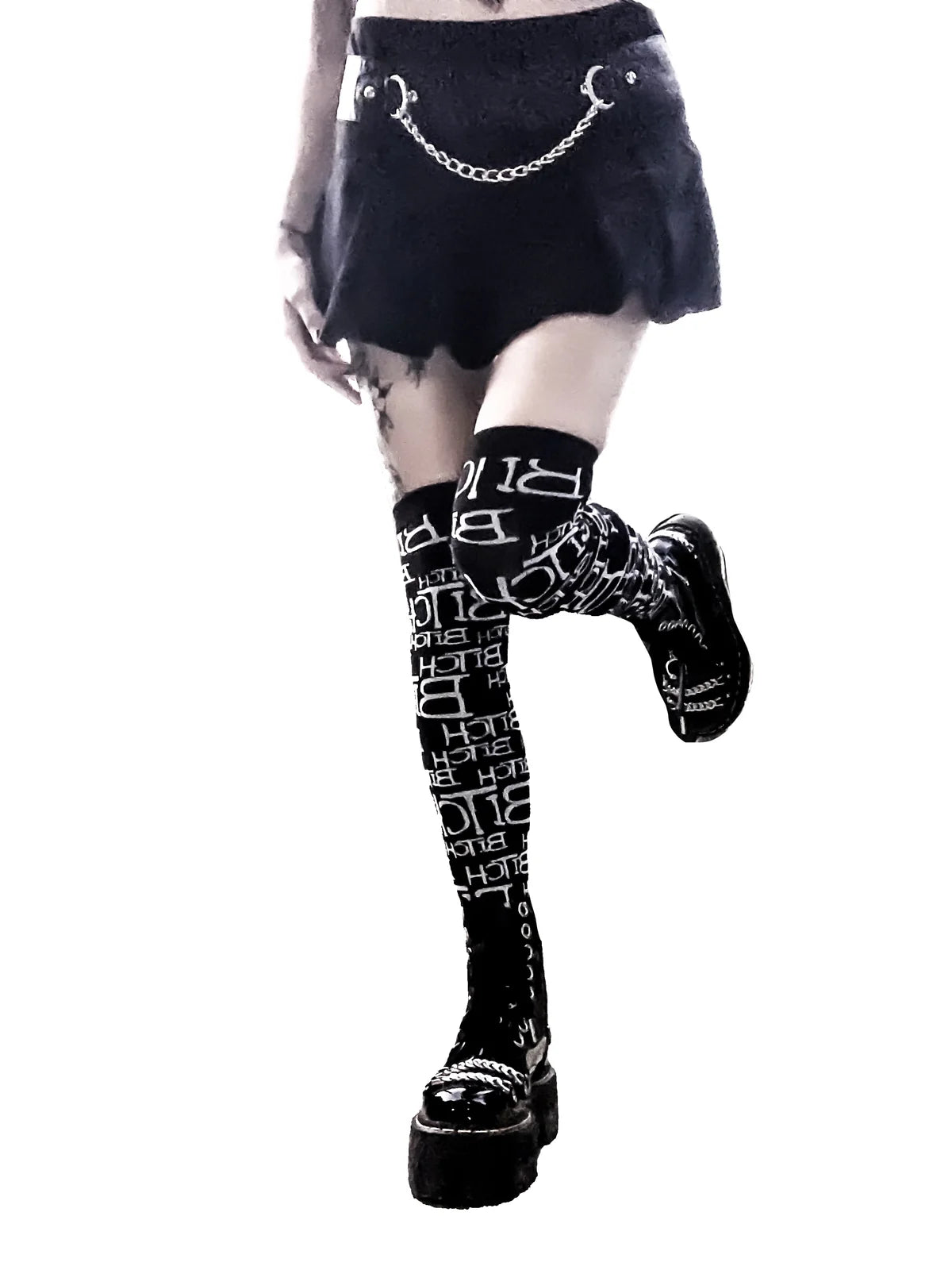 Person wearing lip service  black tights with white text and platform shoes on a white background