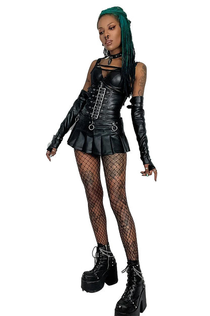 Person wearing a lip service black leather outfit with fishnet stockings and high boots on a white background