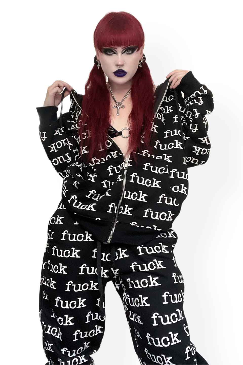 Person wearing a lip service  black and white 'fuck' printed onesie on a white background