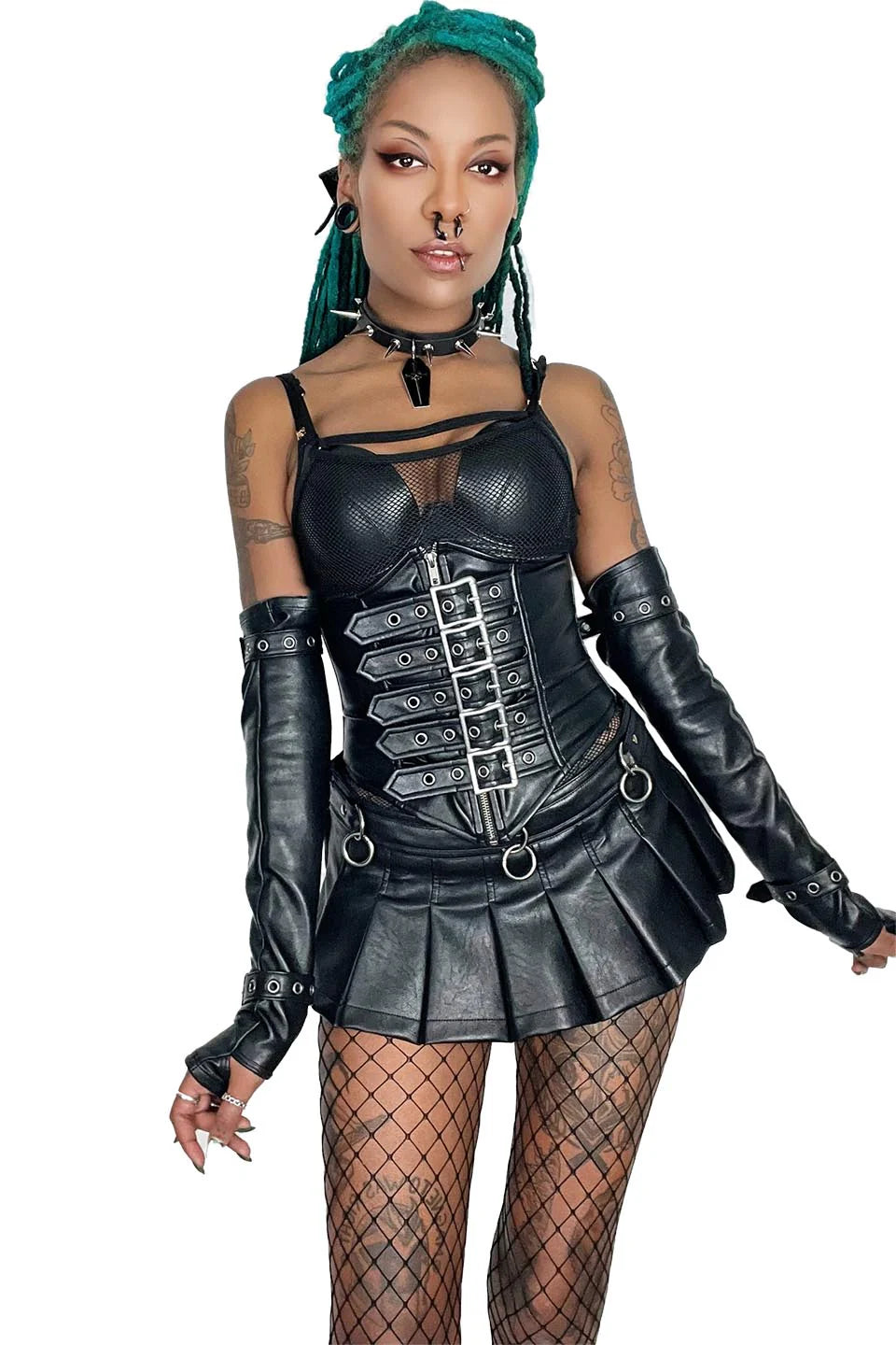 Person wearing a lip service black leather outfit with a corset and pleated skirt on a white background