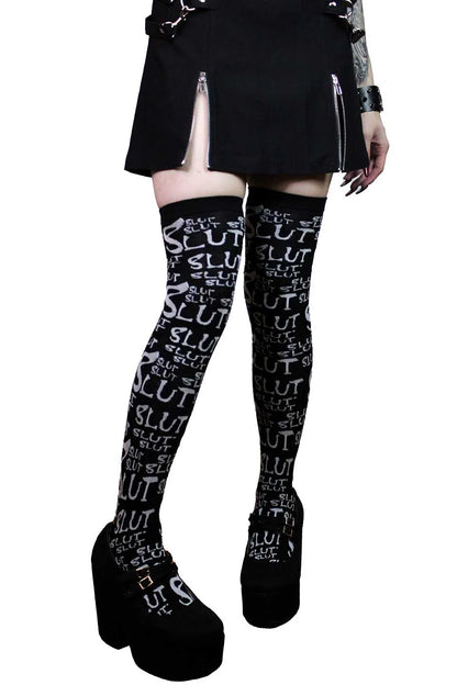 Black lip service knee-high socks with white text worn by a person on a white background