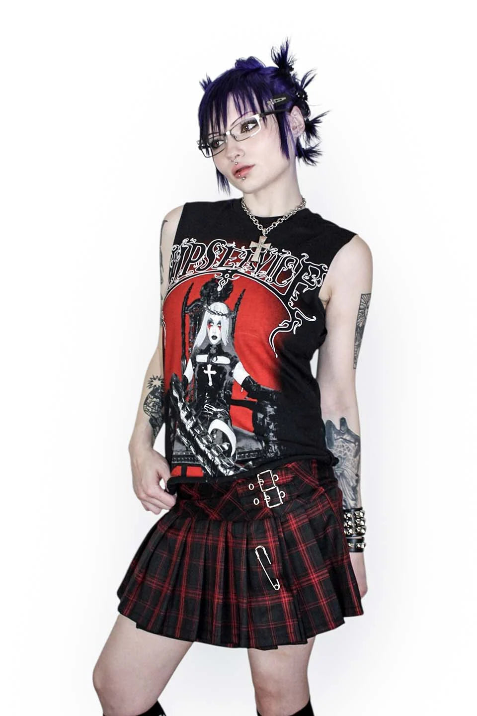 Person wearing a sleeveless top with graphic design and a lip service plaid skirt on a white background