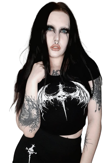 Person wearing a  lip service black crop top with a white design on a white background
