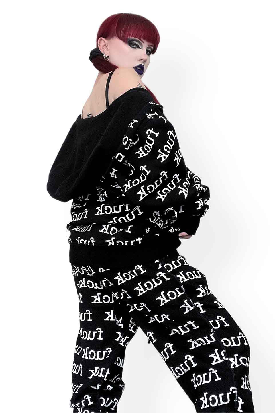 Person wearing a lip service black outfit with white text pattern on a white background