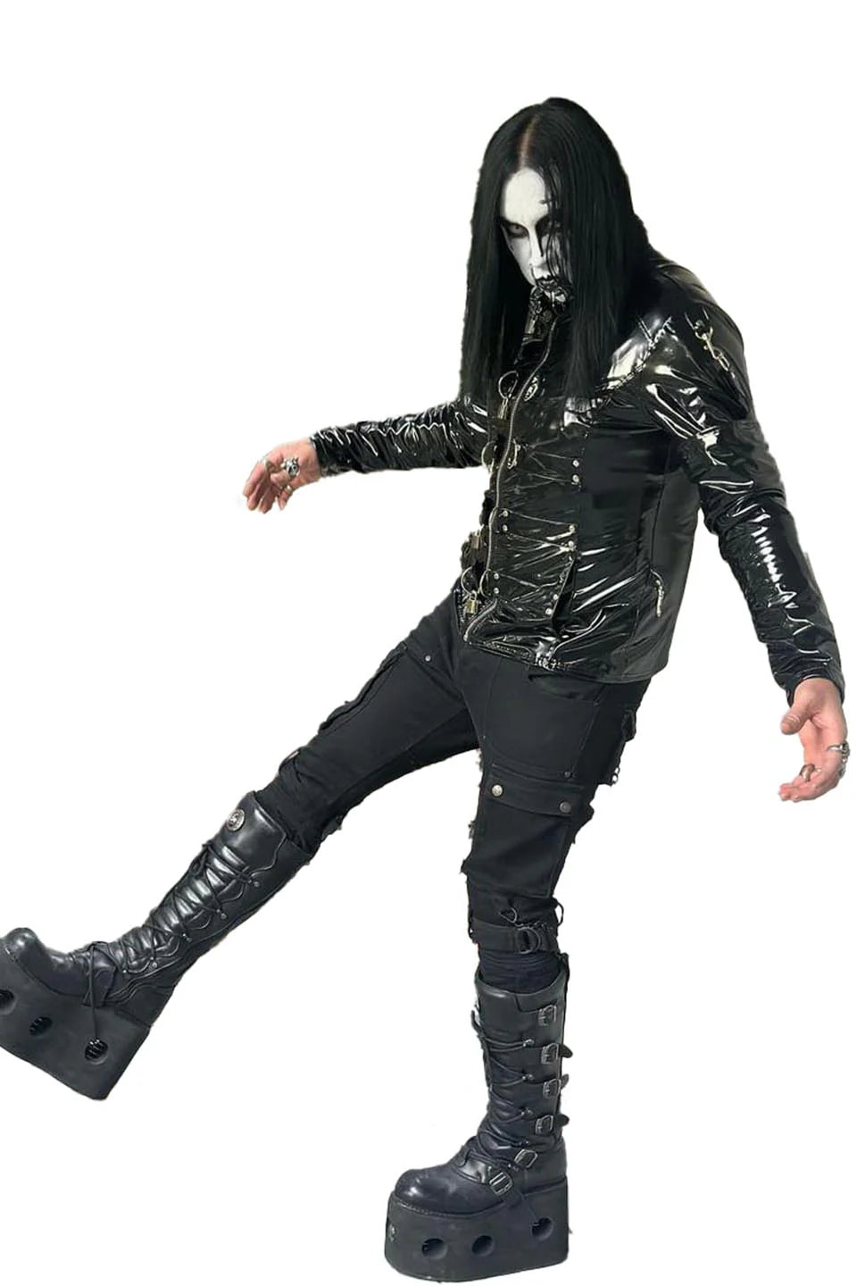 Person wearing a black, reflective outfit with platform boots on a white background